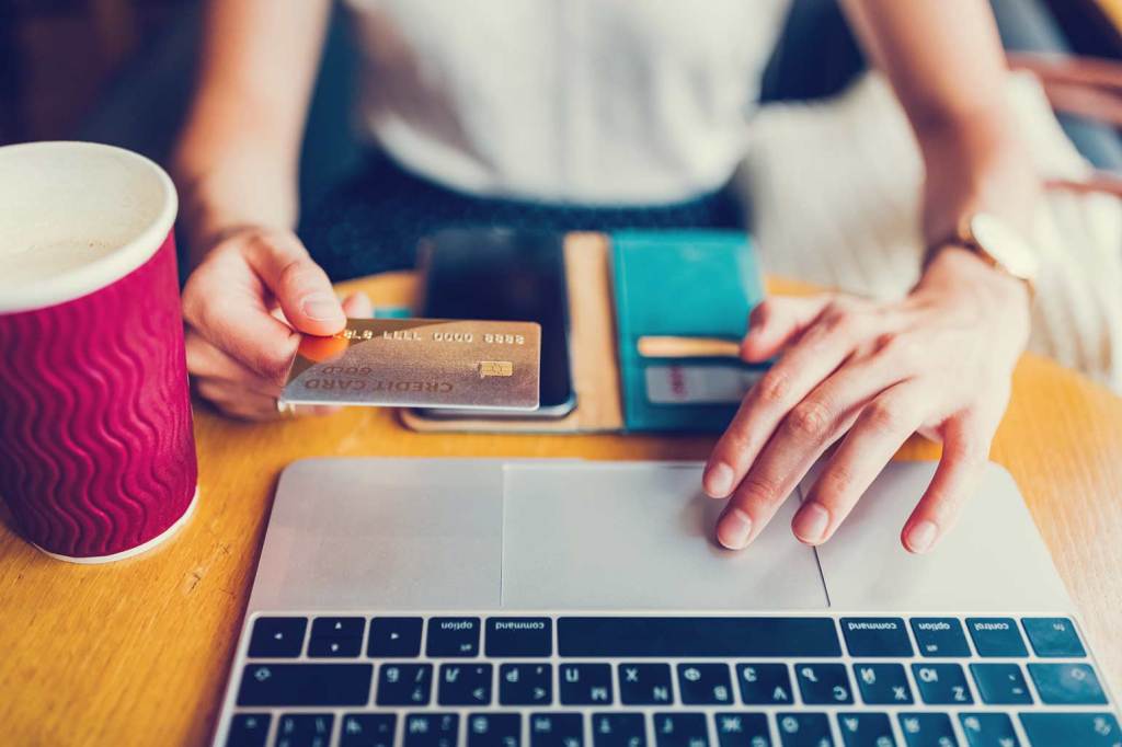 Female hands paying credit card bill on laptop.