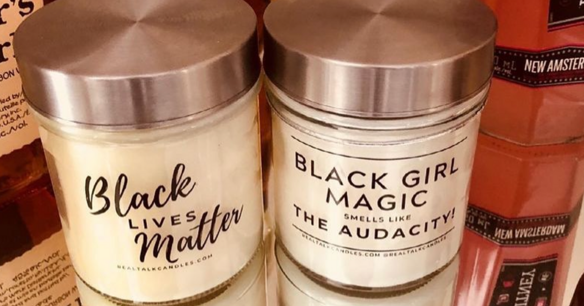 A photo of candles sold by Real Talk Candles. One candle has a label reading "Black Lives Matter" and the other has a label reading "Black Girl Magic. Smells like the audacity".