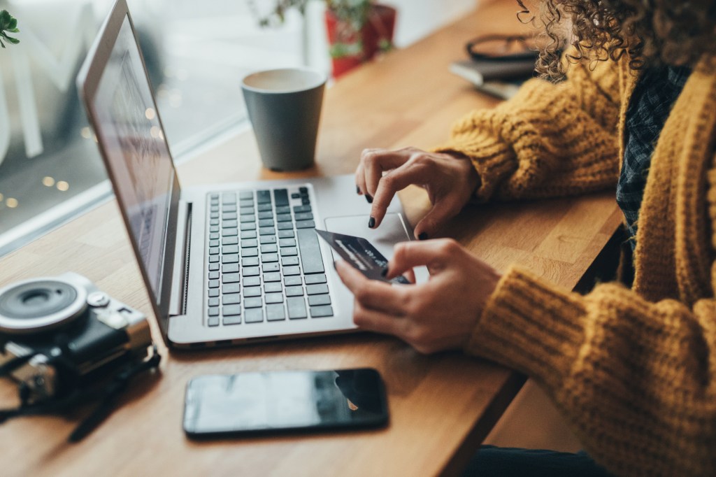 Woman in cafe shopping online with laptop