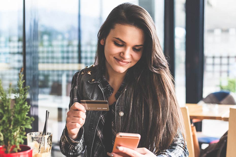 A young woman looking at her credit card