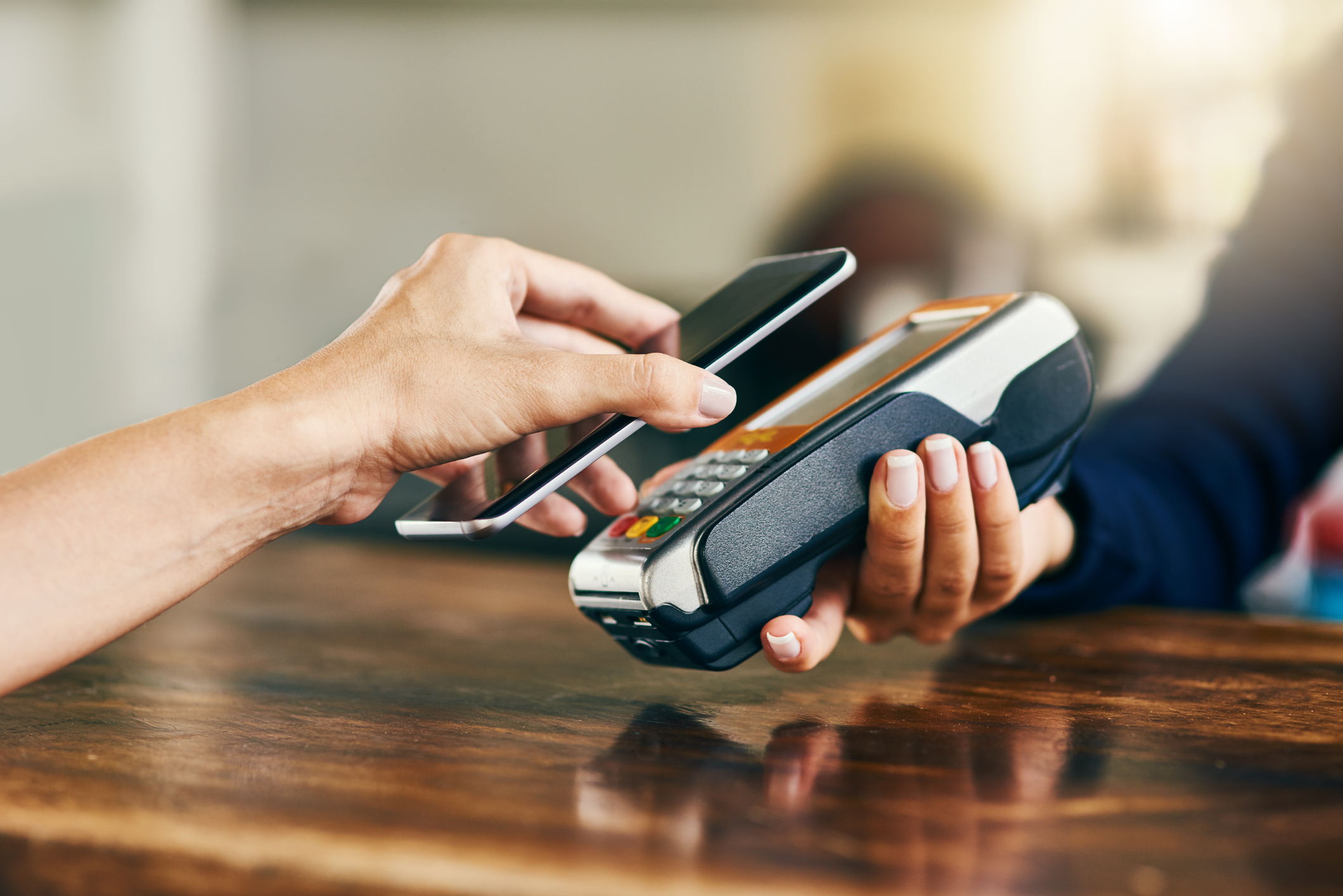A student uses Mobile Pay on a smartphone to pay at a store with contactless credit payments.