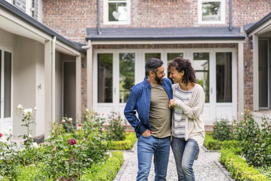 Man and woman stand in front of their house