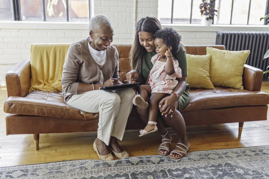 A grandmother, mother, and daughter sit on a couch planning their wealth transfer