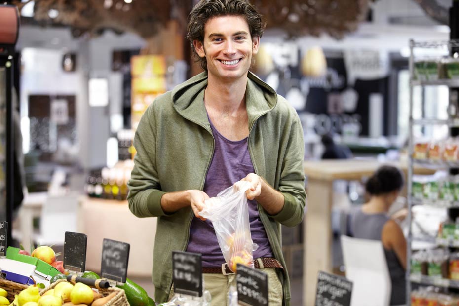 A young man at the store buying fruit