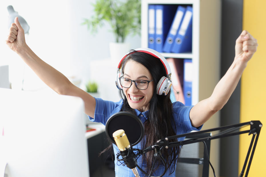 Female podcaster raising her arms in celebration
