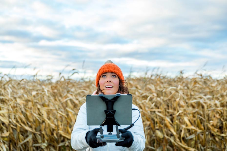 Lady holding tablet in middle of field