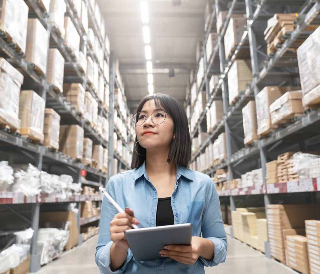 Lady checking inventory list in warehouse