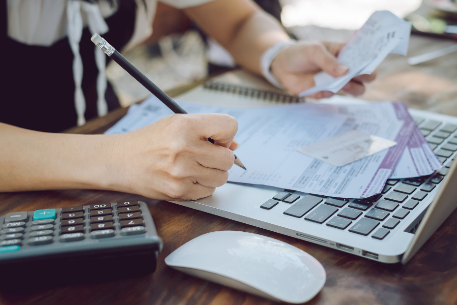 Woman at a desk managing bills with a calculator