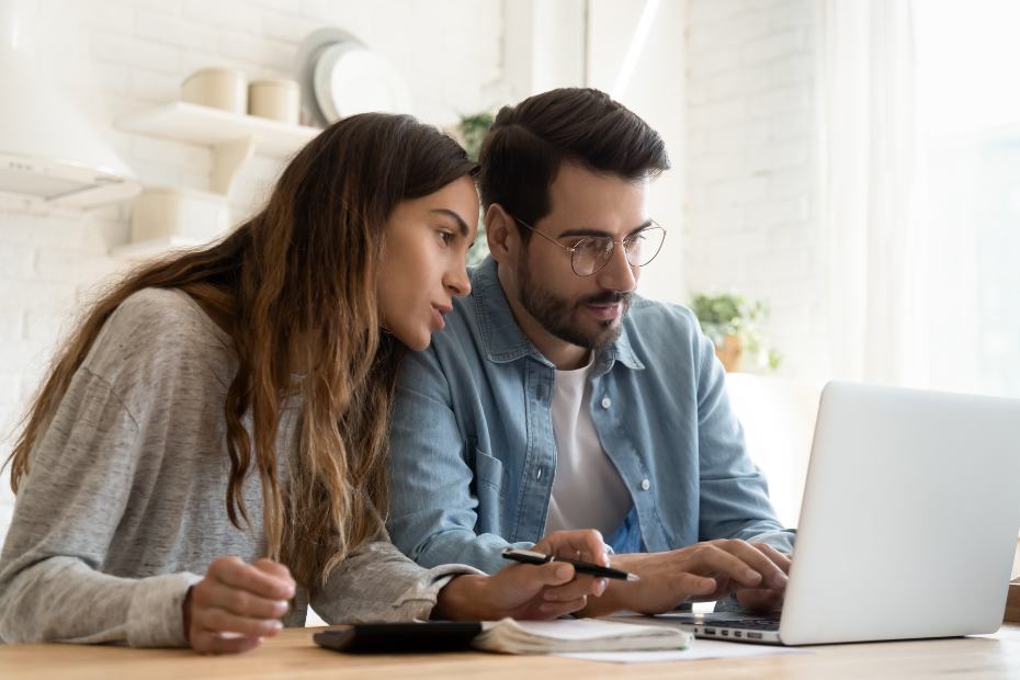 Young couple sitting at a computer looking over their finances together