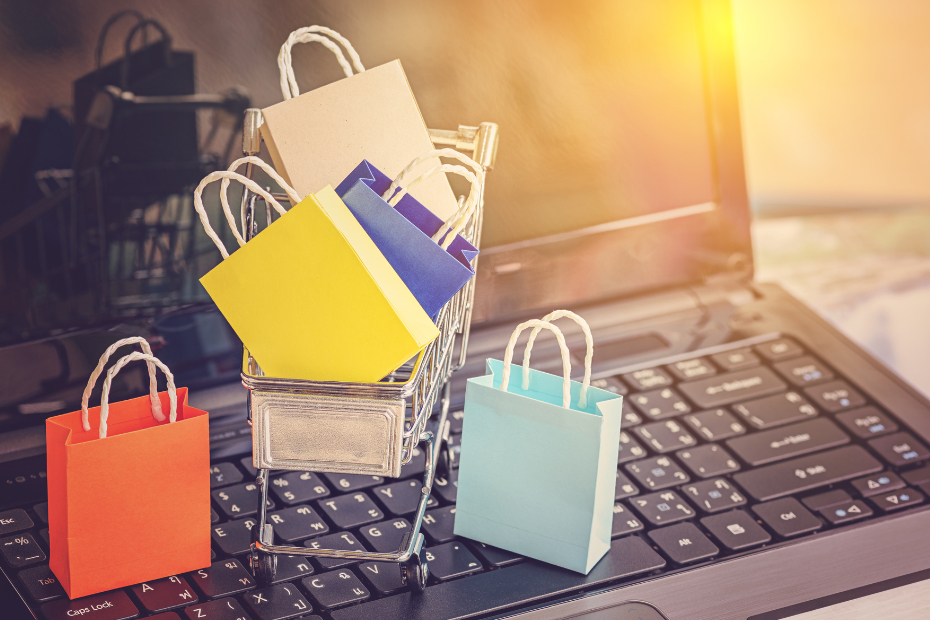 Colourful mini-shopping bags sitting on a laptop