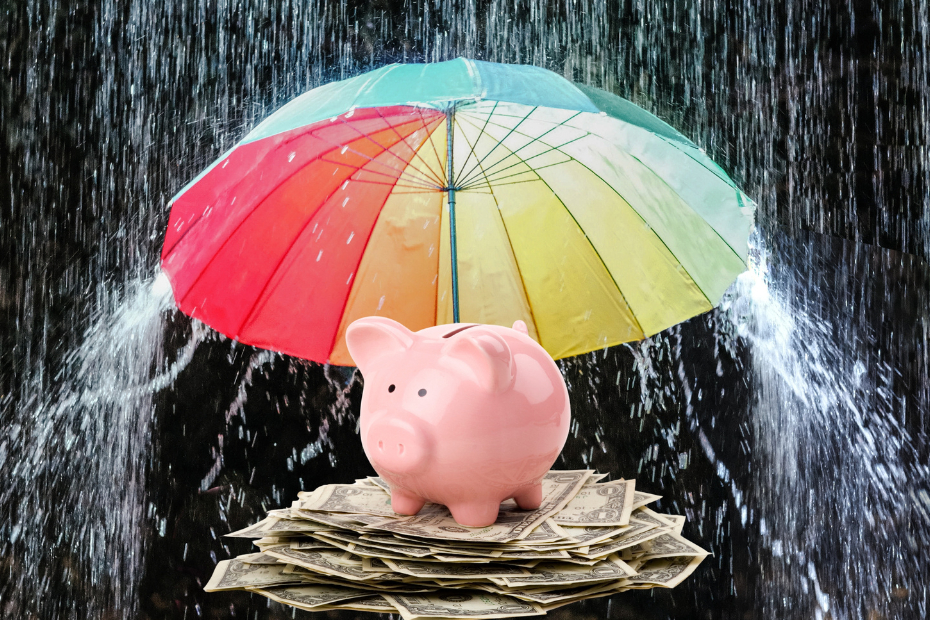 Pink piggy bank shielded from the rains by a colourful umbrella