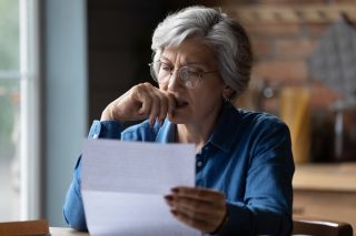 A middle-aged woman looking at a financial statement