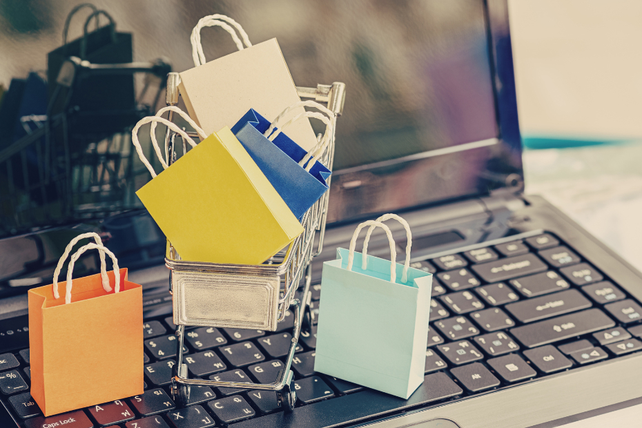 Miniature paper shopping bags sitting on a Laptop