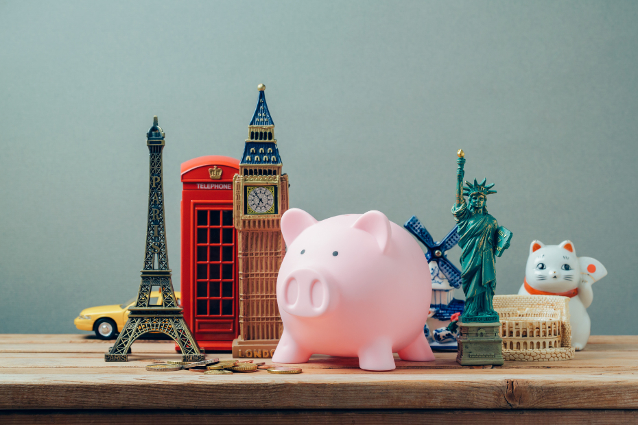 Desk with figurines of Big Ben, Eifel Tower, Statue of Liberty and a piggy bank.