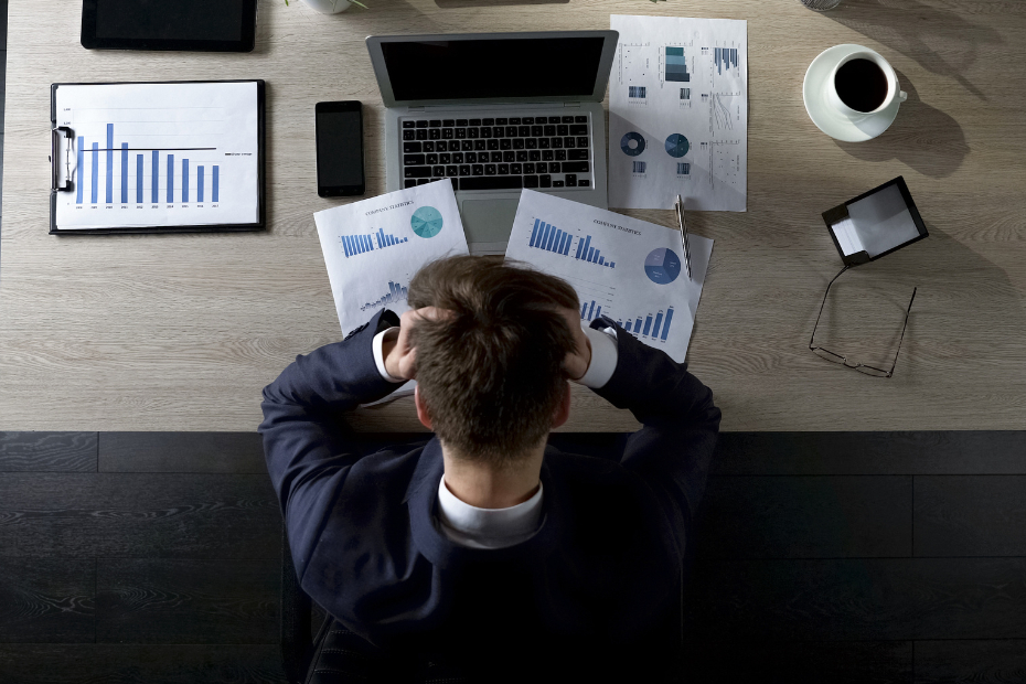 Young man at a desk upset about debt