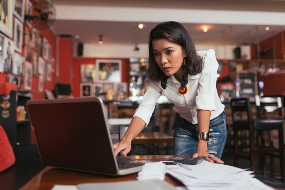 Concerned entrepreneur leaning on a desk, facing financial challenges