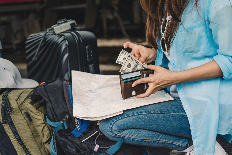 Close up of young woman with backpack counting US dollars in wallet