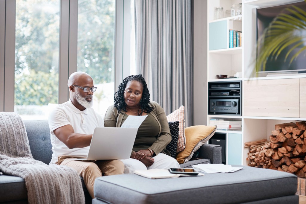 Couple sitting on a couch with a laptop