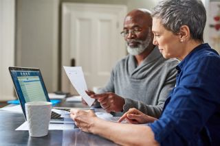 An elderly couple looking over financial documents together