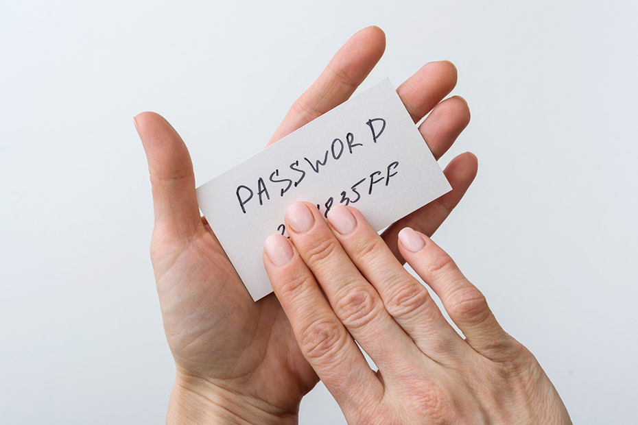 A card with "Password" written on it with a hand concealing the numbers and letters of a password