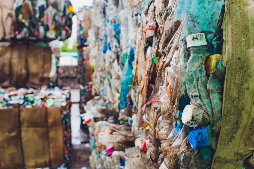plastic recycling ground with huge piles of compressed plastic.
