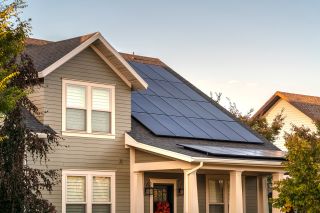 Solar panels on a large, detached home can generate renewable electricity.