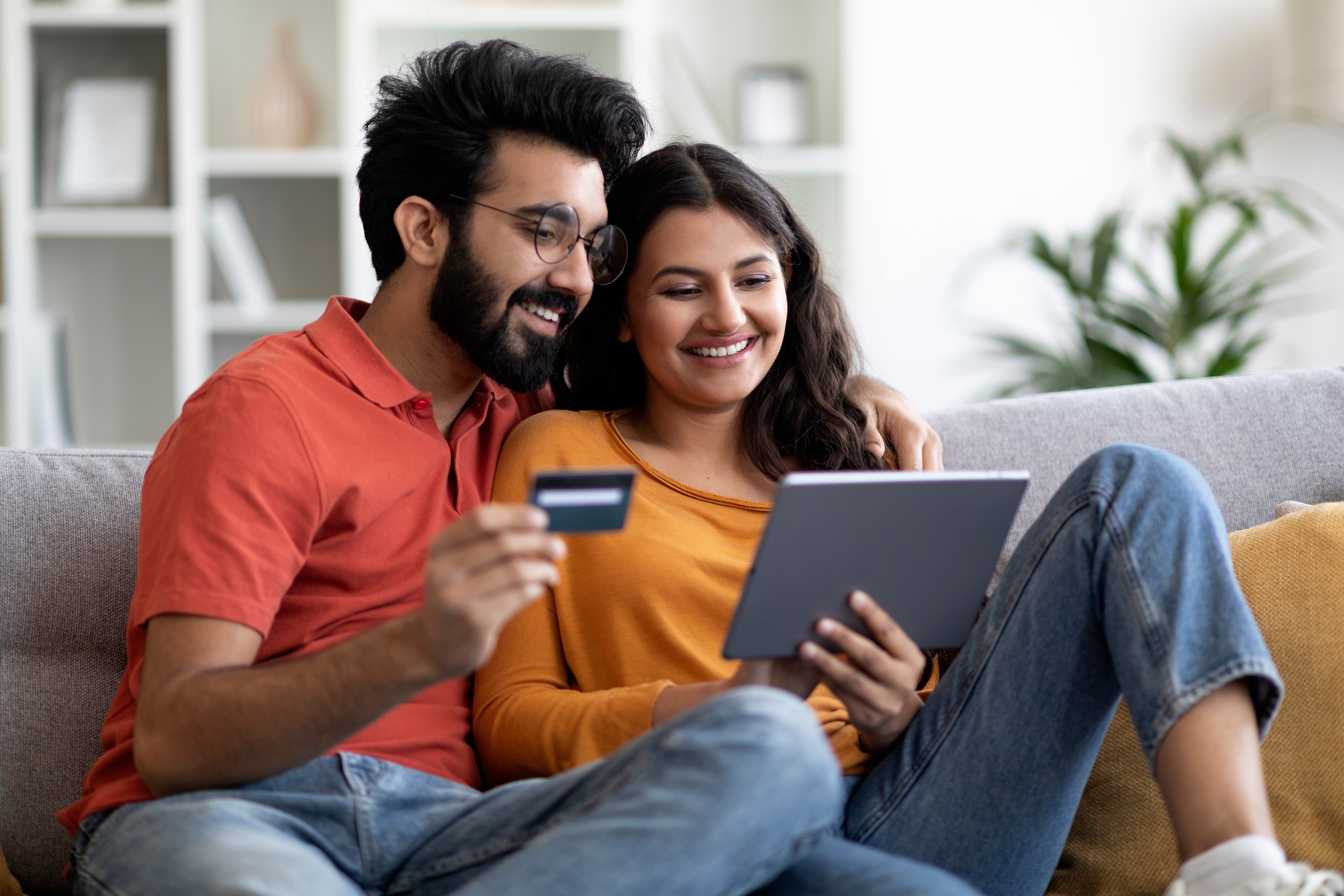 A couple entering their credit card details on a tablet