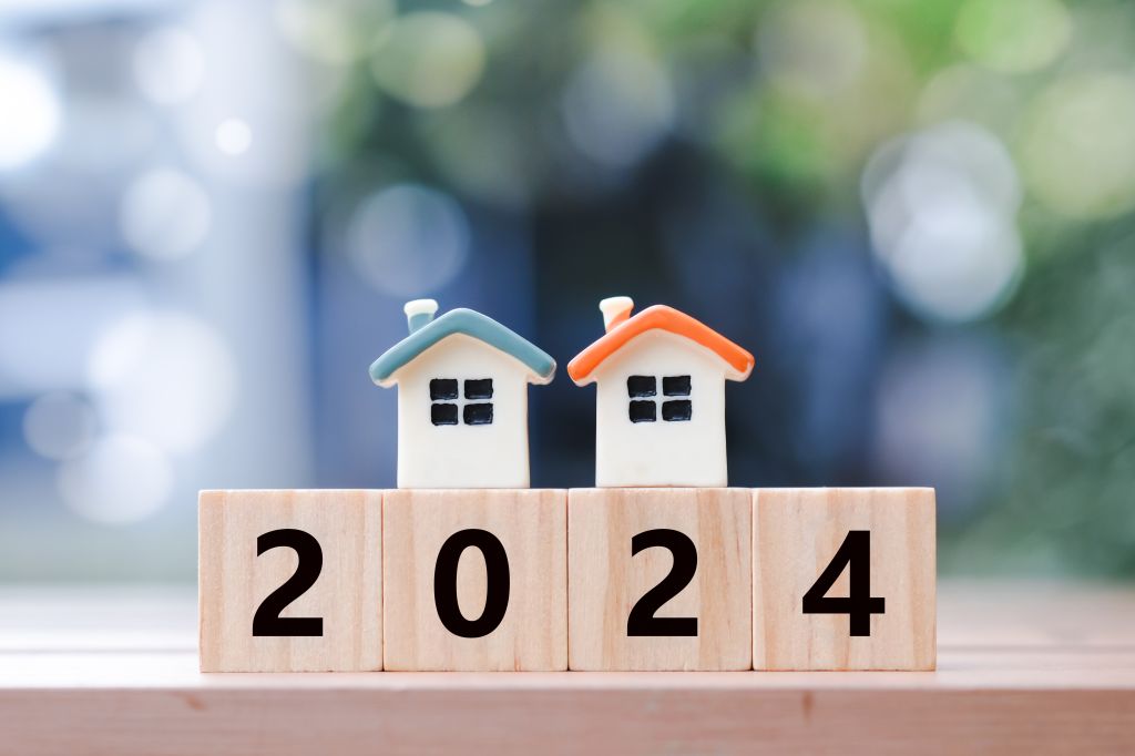 Wood blocks spelling out 2024 with miniature houses on top