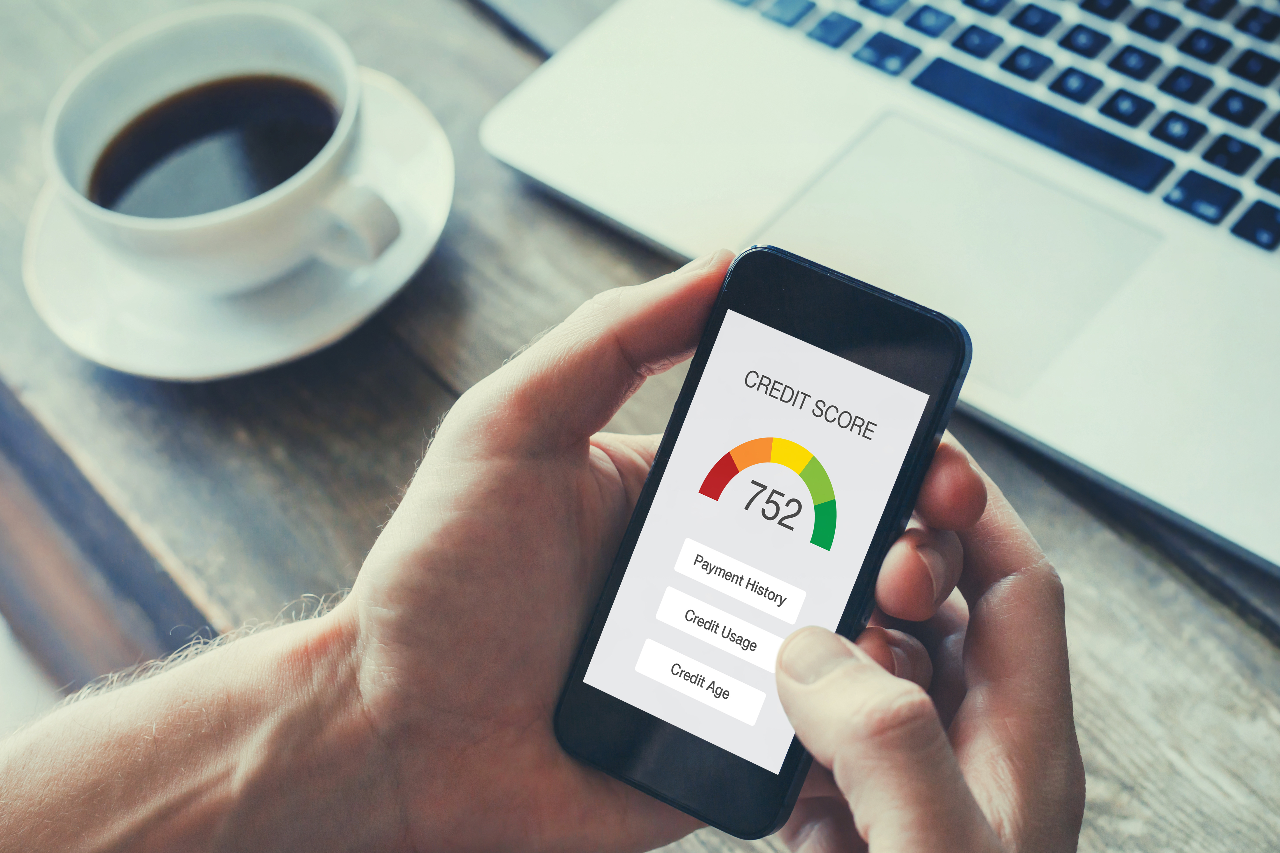 Image of person looking at an app on their smartphone to check their credit score.