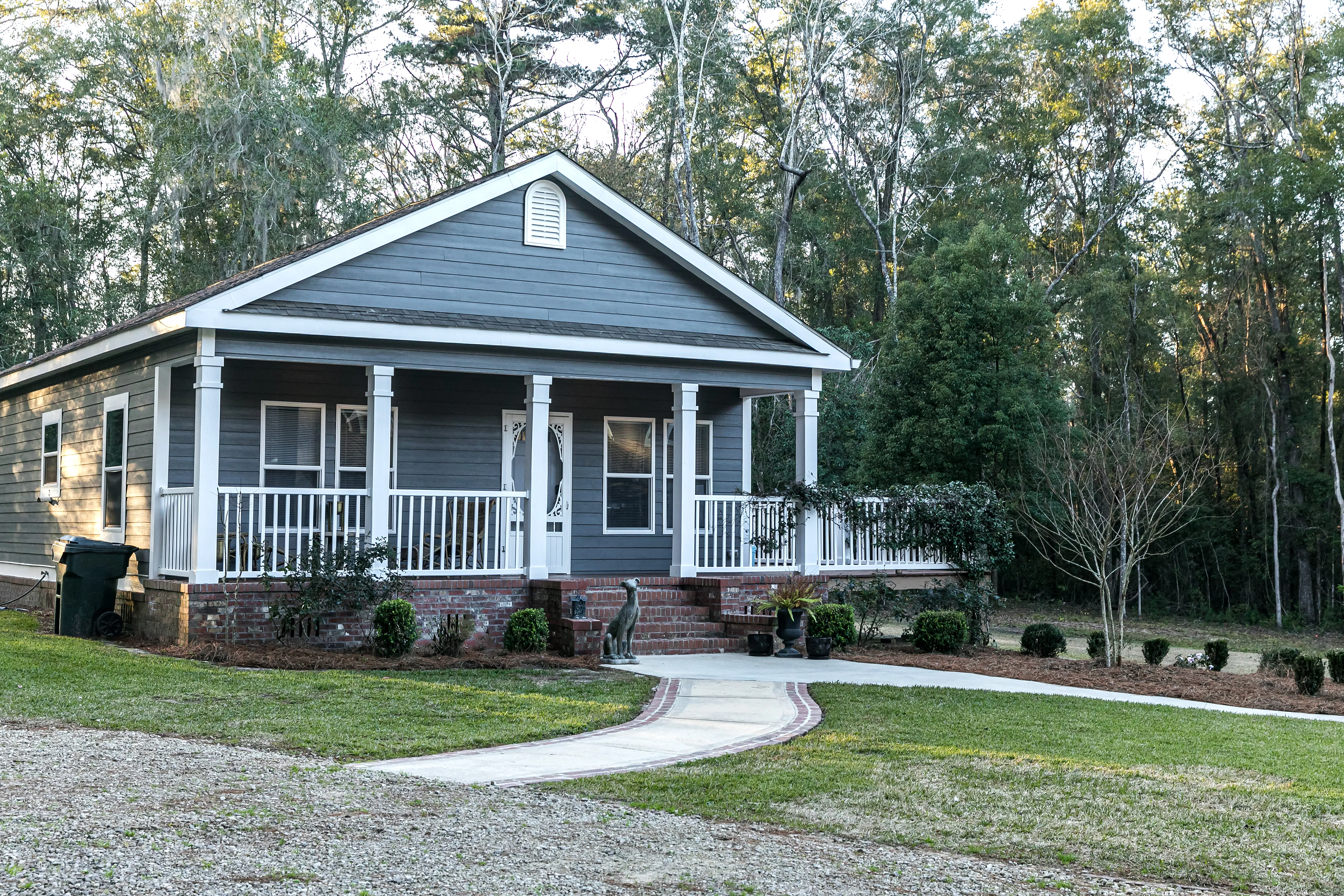 Small blue gray mobile home with a front yard