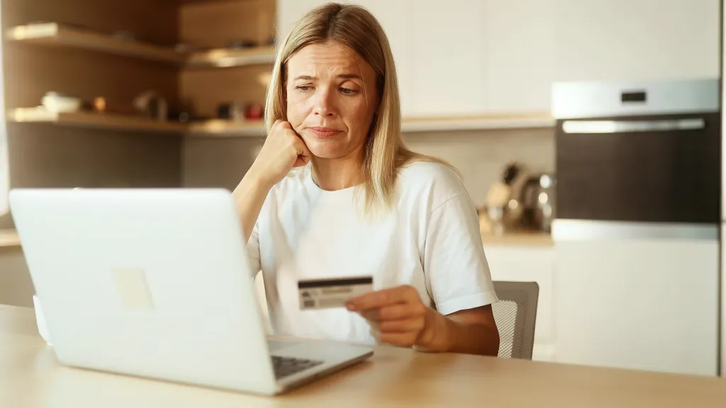 Confused women with a credit card looking at the screen
