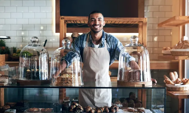 Bakery, happy and portrait of man in cafe ready for serving pastry and baked foods for small business.