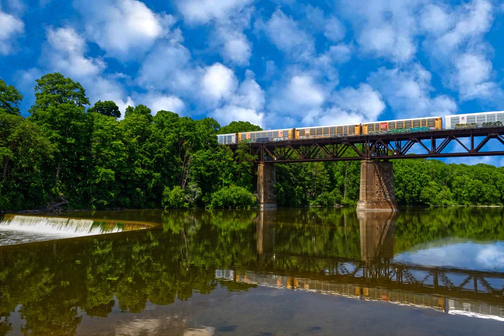 A freight train crosses a bridge over water in Ontario, Canada.