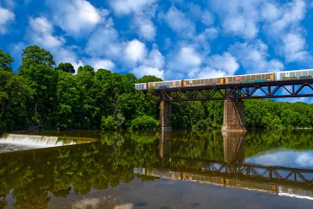 A freight train crosses a bridge over water in Ontario, Canada.