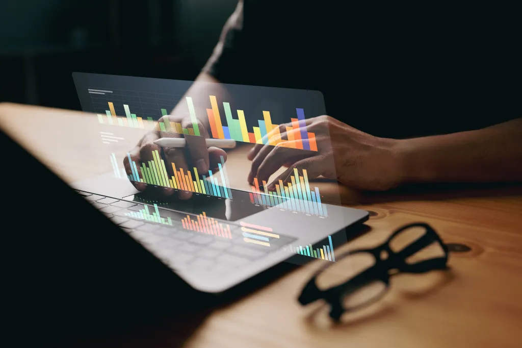 A laptop with graphic overlay of charts and graphs