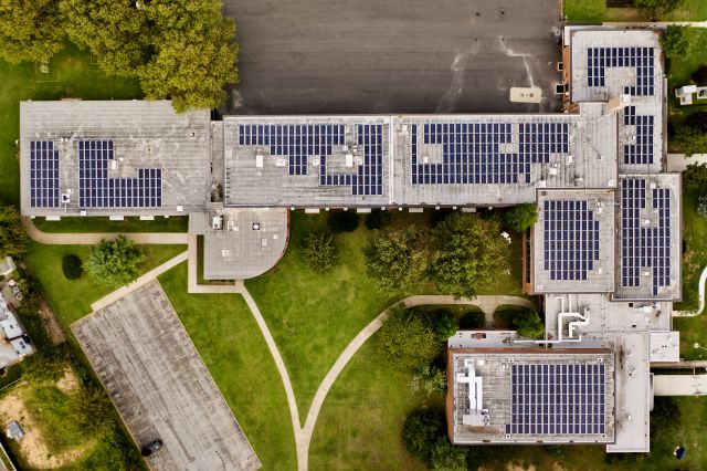 Aerial view of a factory building with solar panels on the roof of the building