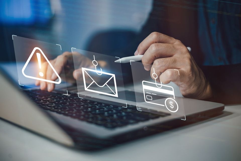 Person pointing at three fraud icons on a computer screen.