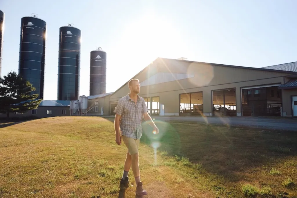 Man walks in front of a farm building in Canada