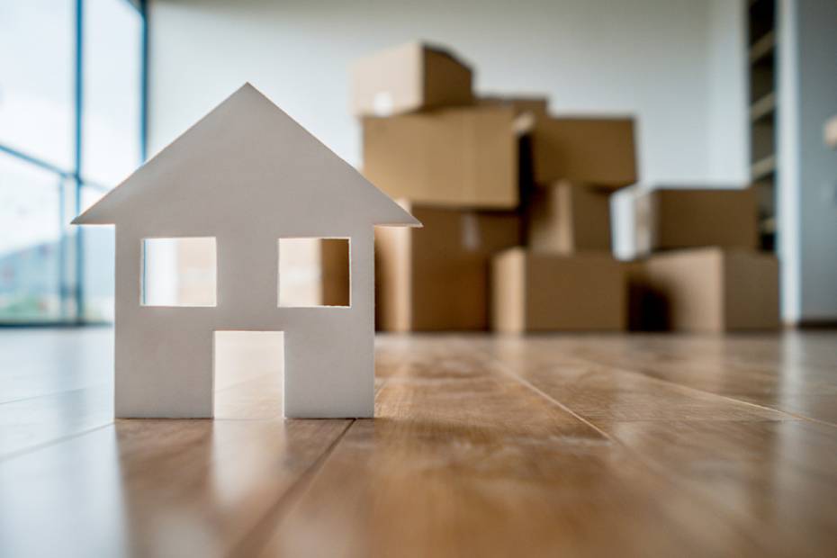 Une petite maison en papier posée sur une table de salon