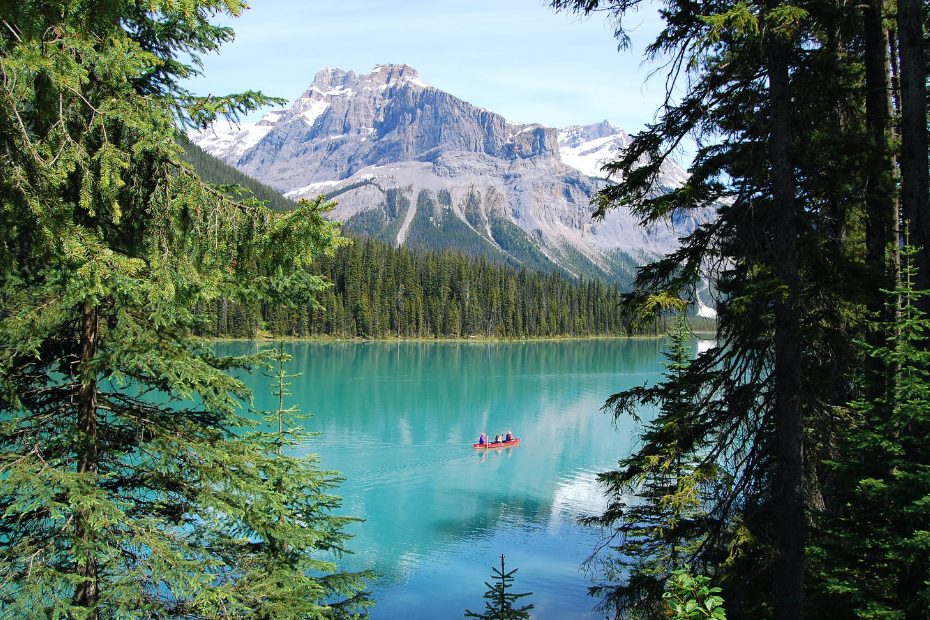 La nature, les montagnes et un canoë orange au milieu.