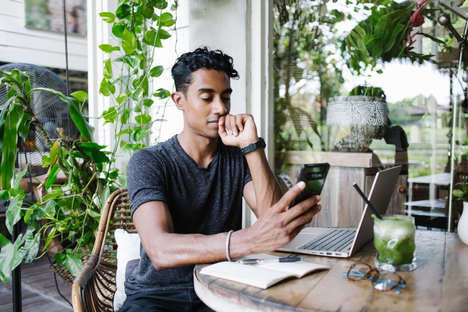 Un investisseur curieux se renseigne au sujet des notions économiques sur un téléphone mobile.