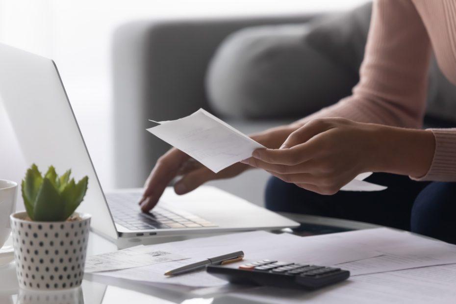 Image floue d'une femme en train de payer des factures sur son ordinateur