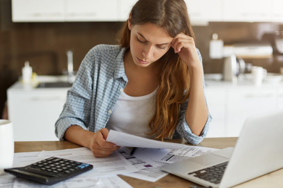 Femme attablée à un bureau, stressée par ses finances