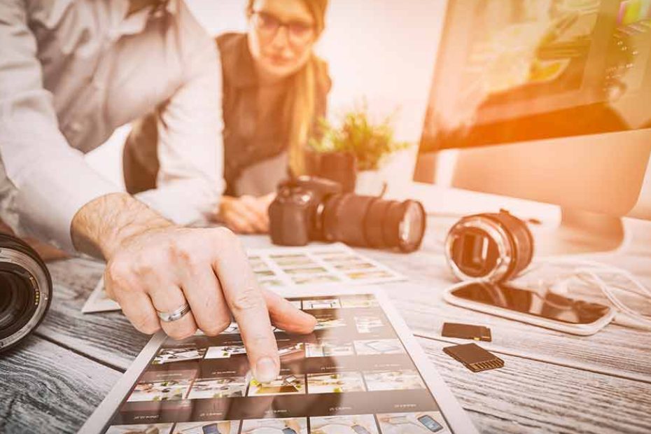 Un homme et une femme regardent des photos sur un bureau.