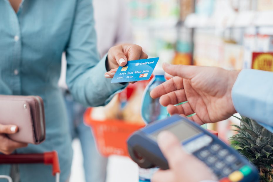 Femme dans une épicerie, payant avec sa carte de crédit