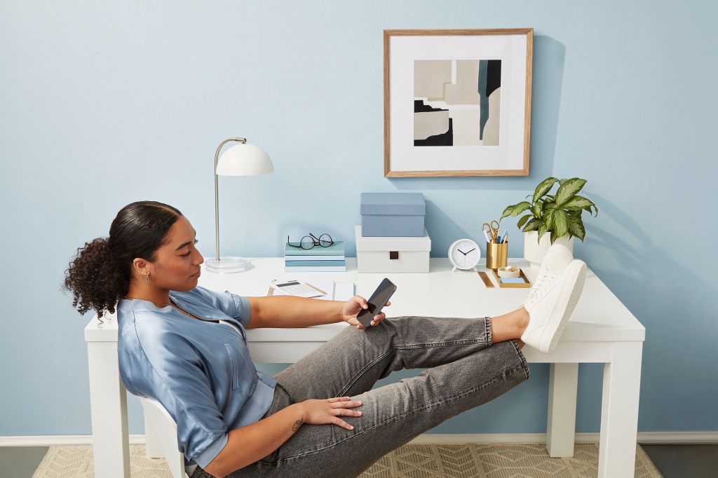 Femme assise au bureau avec les pieds vers le haut