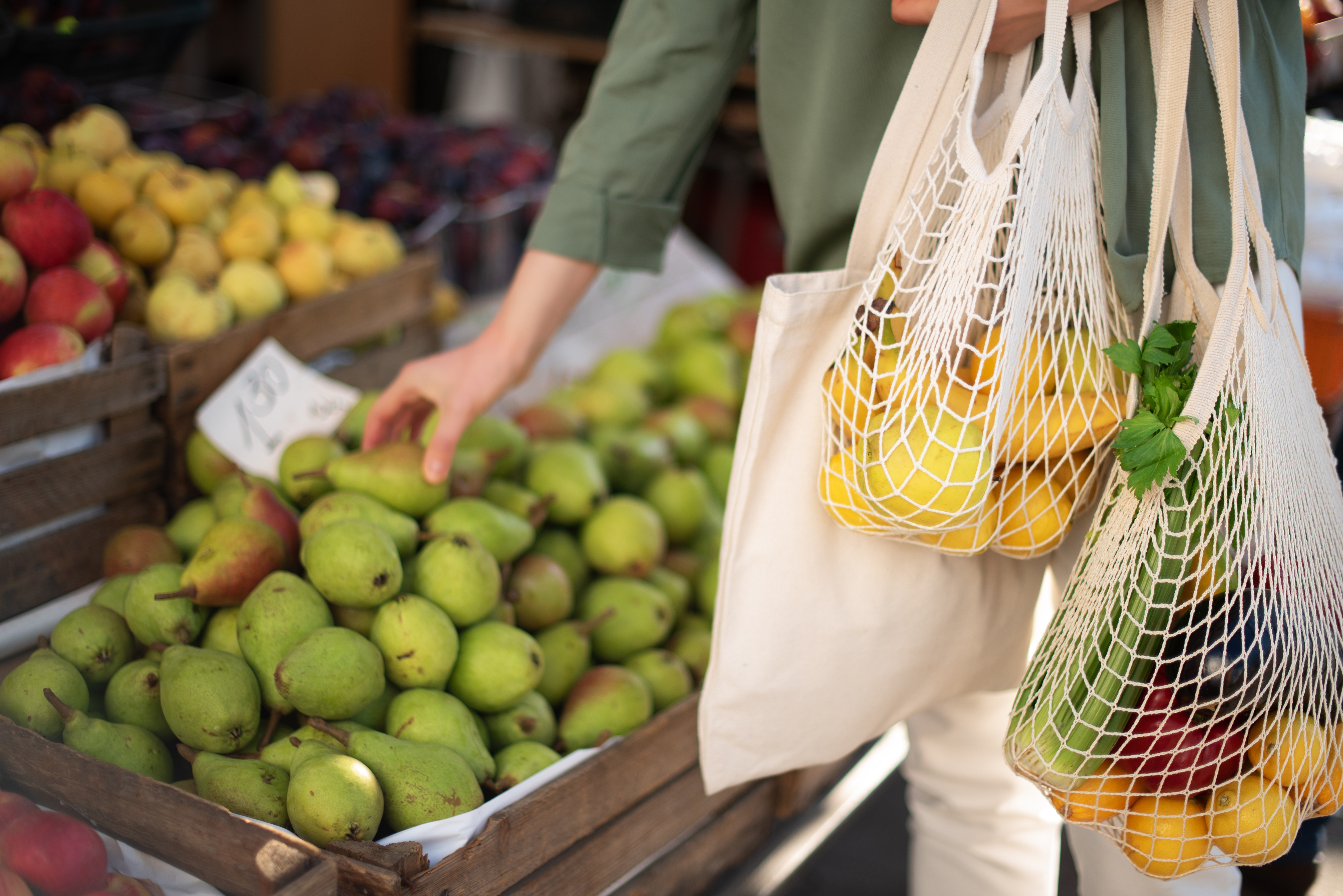 Un acheteur réduit la quantité de déchets plastiques à usage unique en apportant ses propres sacs et en achetant des produits sans emballage.