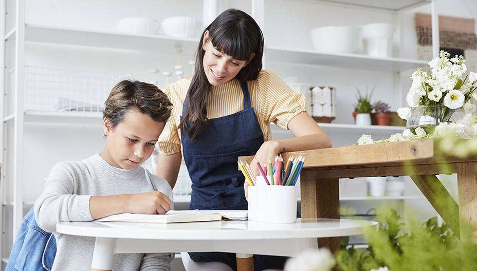 Mère aidant son fils à faire ses devoirs à une table de cuisine.