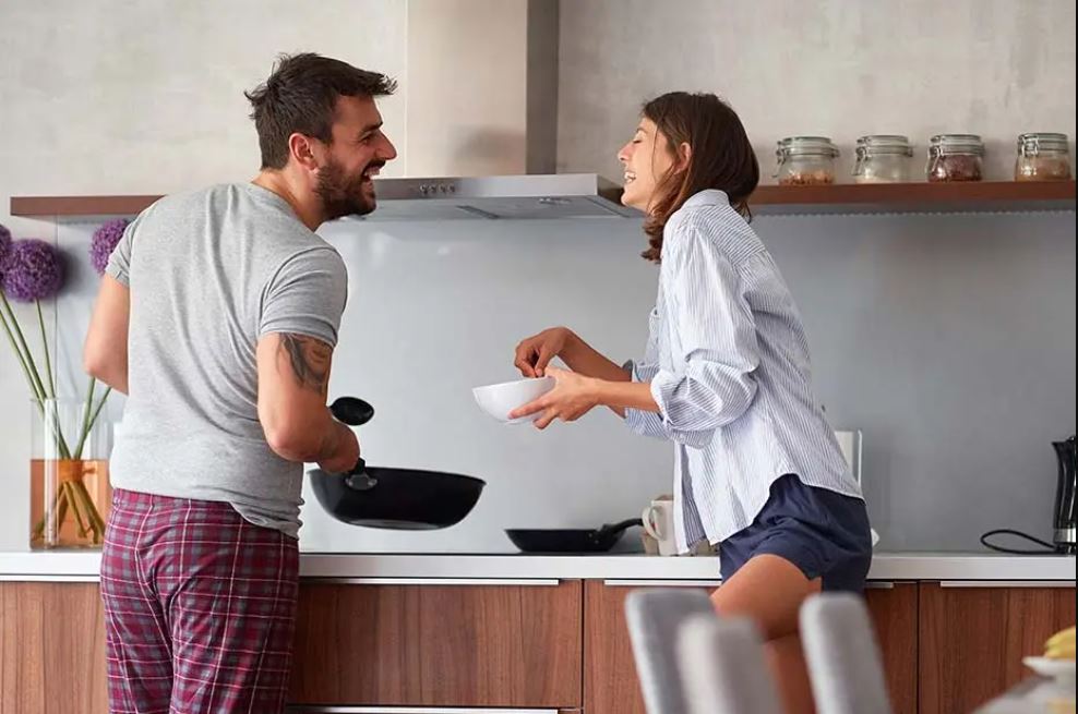 Jeune couple qui s’amuse en cuisinant.