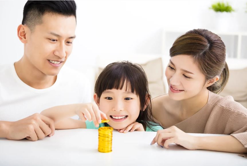 À la table de la cuisine, de jeunes parents parlent d’argent à leur fillette